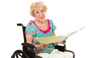 Senior woman in wheelchair holding a stack of bills. Full body isolated on white.