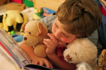 boy with stuffed toys reading